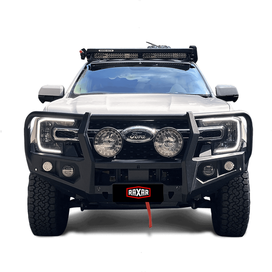 White Ford pickup with front bull bar, spotlights, and roof-mounted lights.