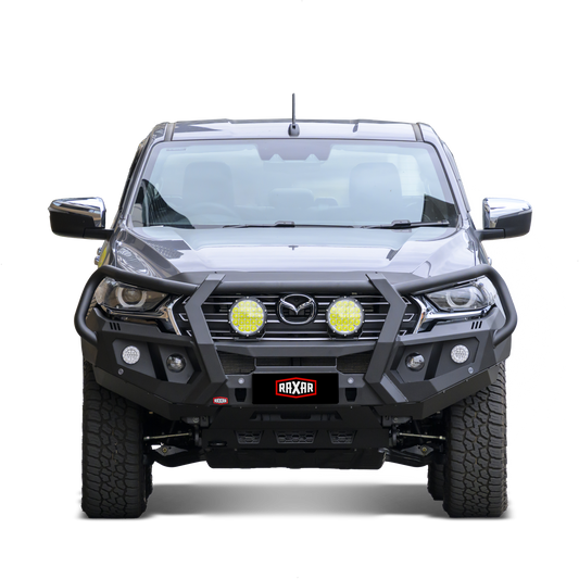 Mazda pickup with rugged bull bar and mounted auxiliary lights.