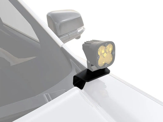 Compact off-road light mounted on a car's fender with a sturdy bracket.