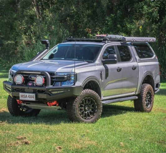 Silver 4x4 vehicle equipped with off-road modifications and roof accessories