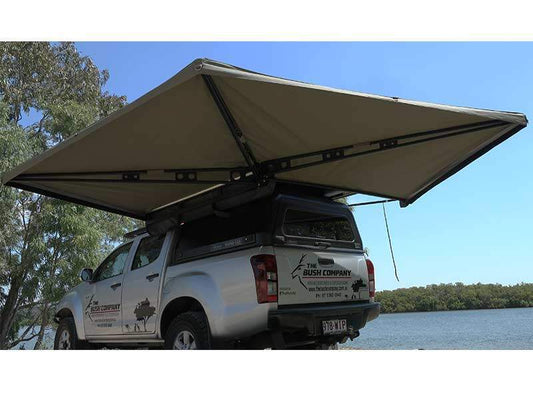 Pickup truck by lakeside with extended canopy for shade, trees, and water. 800