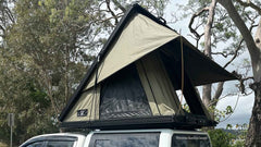 Pop-up rooftop tent mounted on a vehicle for camping.