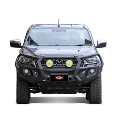 Mazda pickup with rugged bull bar and mounted auxiliary lights.