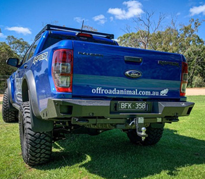 Blue Ford Ranger Raptor with off-road mods, website URL on tailgate.