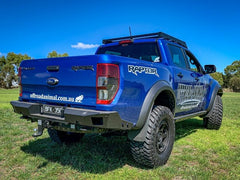 Blue Ford Ranger Raptor with off-road mods, website URL on tailgate.