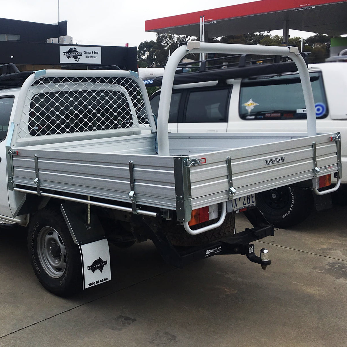 Flatbed utility vehicle with metal mesh headboard, aluminum sides, tow hitch.