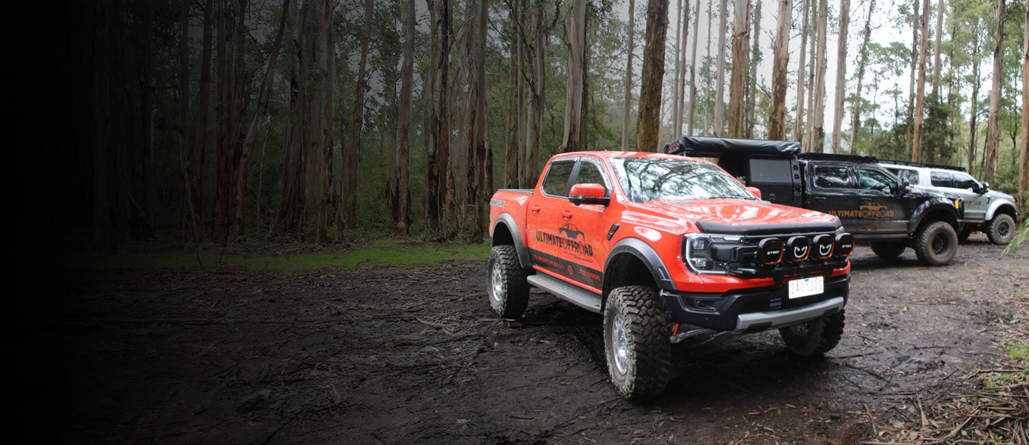 Ultimate Offroad truck parked in forest setting.