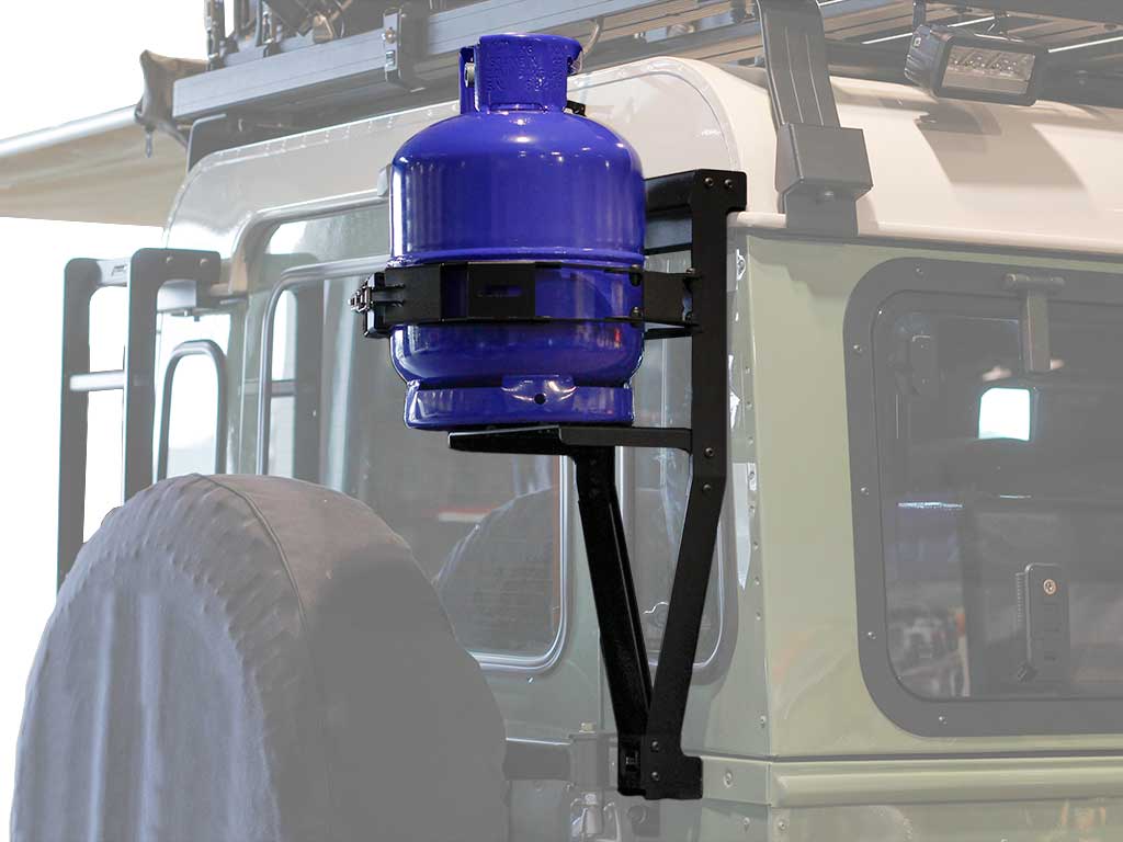 Blue gas cylinder mounted on vehicle side with black metal bracket.