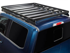 Blue Ford Super Duty truck with roof rack, chrome accents, crew cab.