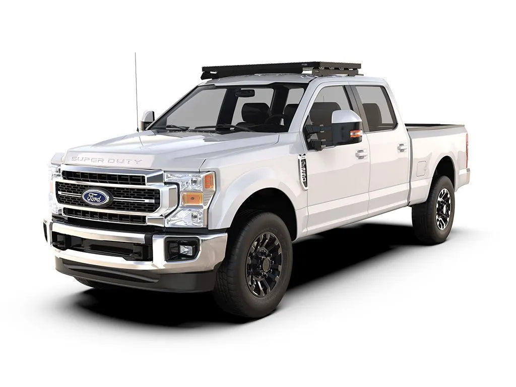 White Ford Super Duty with roof rack, front and side view, white background.