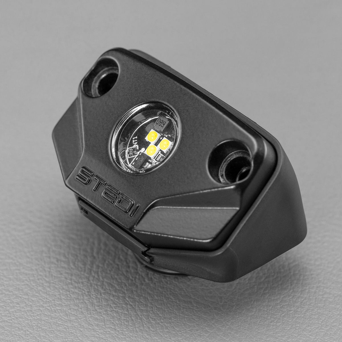 Black LED light accessory, two screws, STEDI brand, gray surface.