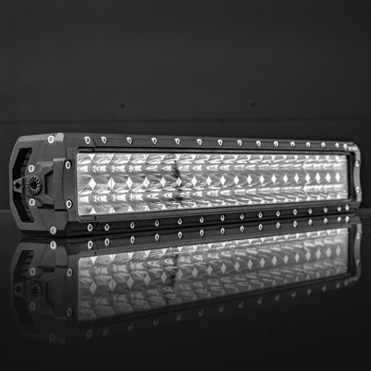 Black LED light bar with multiple lights in rows, reflection on glossy surface.