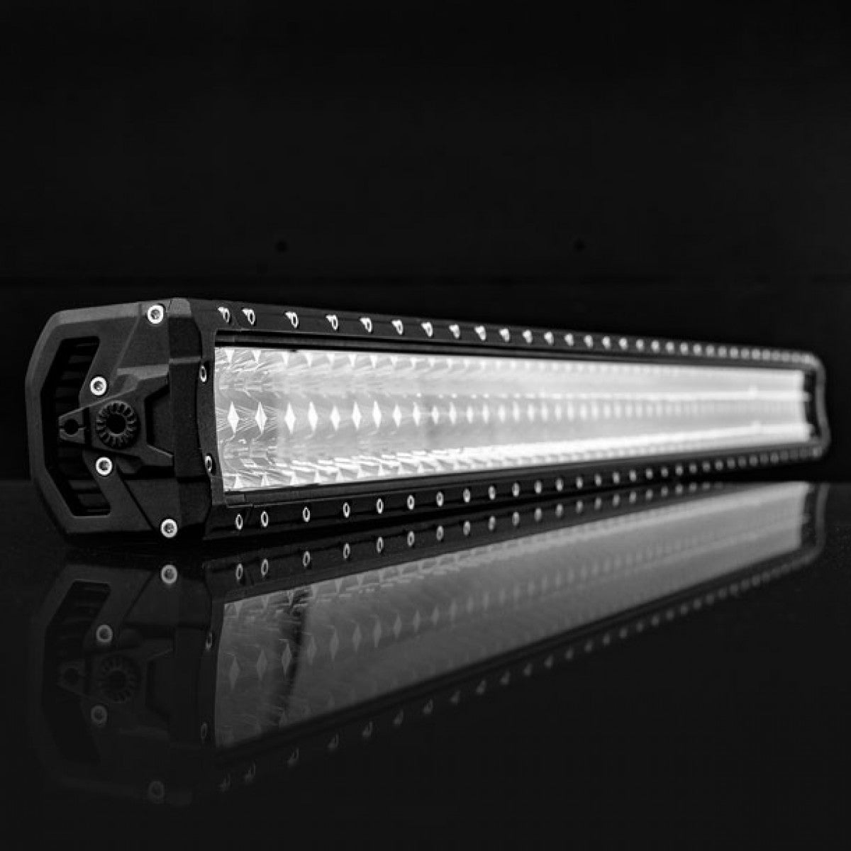 Black LED light bar with small lights, on reflective surface, dark background.